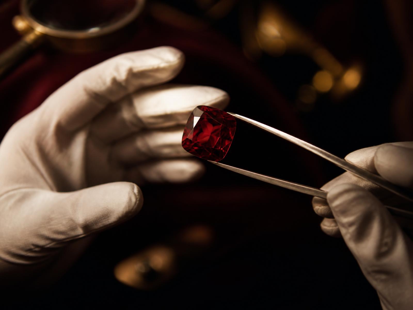 A rare cushion-cut gemstone examined under controlled light in a private salon